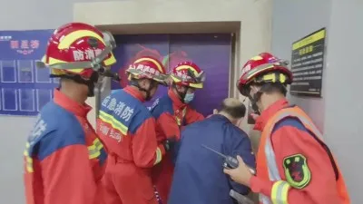 云南个旧:电梯突发故障4人被困 消防撬门救人