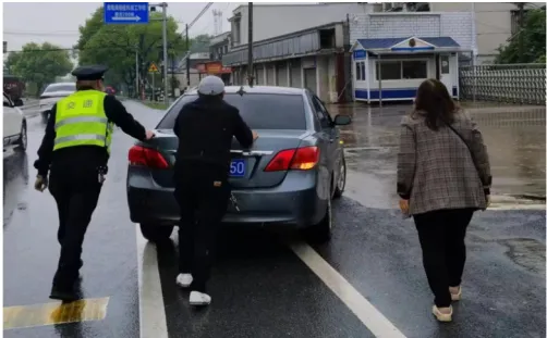 轿车行驶途中抛锚  湘潭交通执法人员冒雨合力推车、暖心助力
