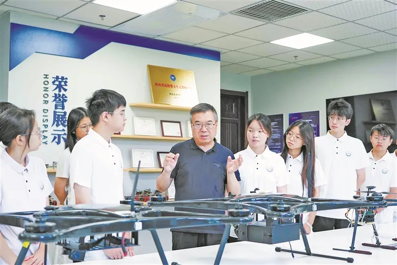西安电子科技大学教授马建峰(中)与学生交流。 受访单位供图
